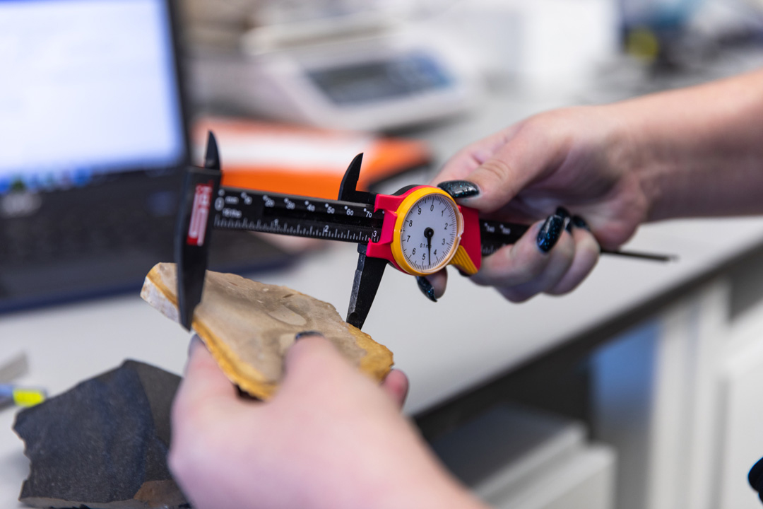 A PhD student in the CASHP Stone Age Archaeology lab working with rock samples