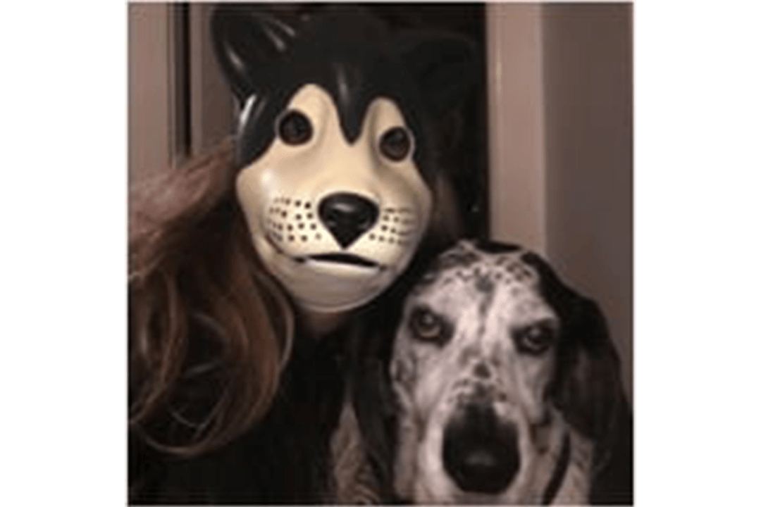 a human wearing a dog mask next to a dog